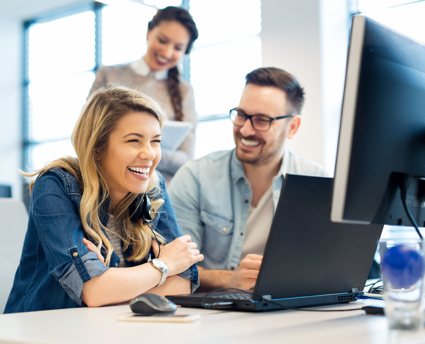 three coworkers sitting together laughing