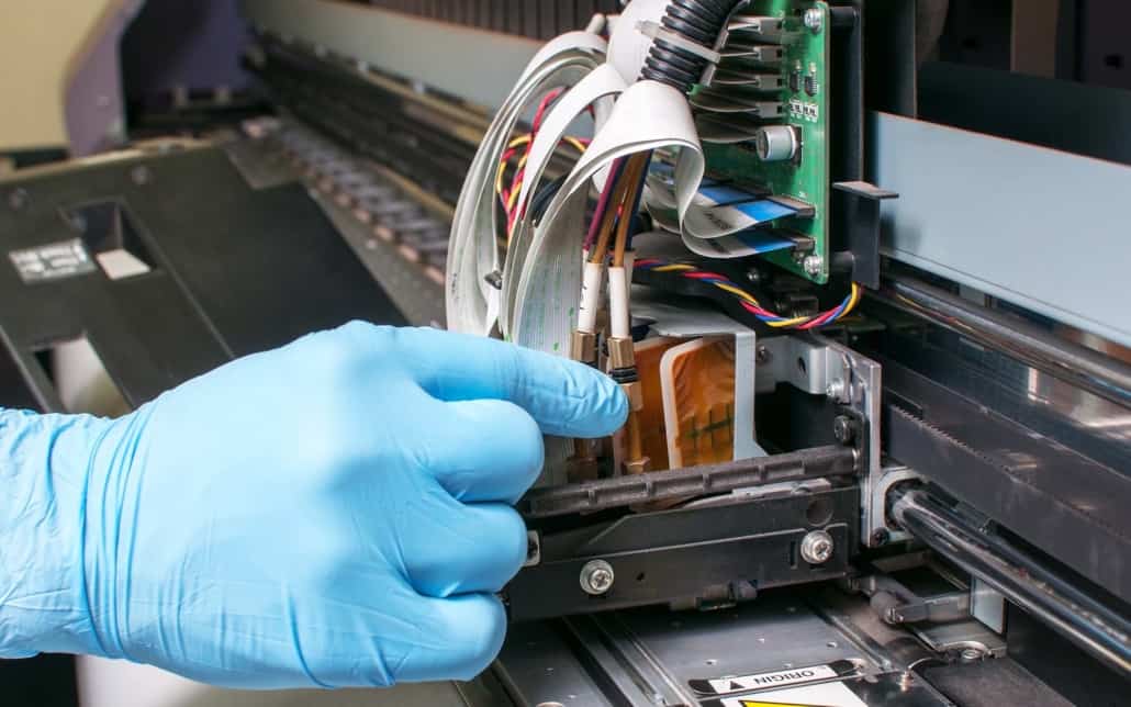close up of person fixing the inside of a printing machine