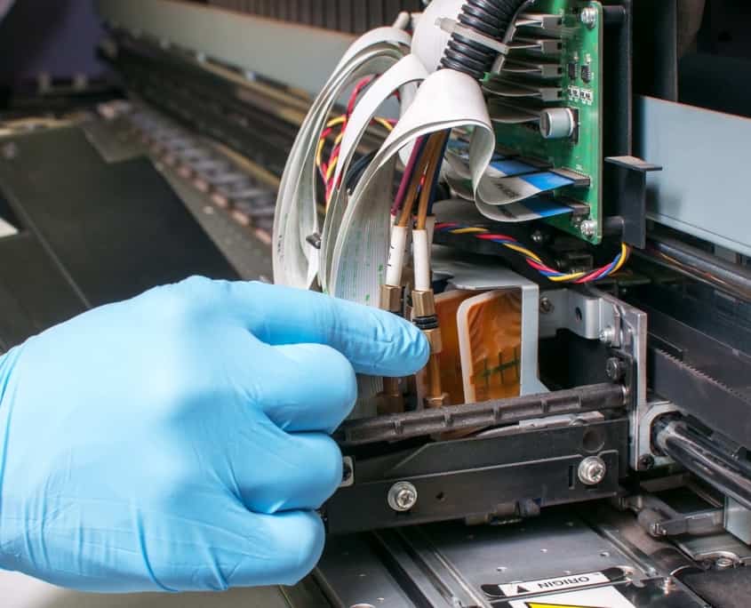 close up of person fixing the inside of a printing machine