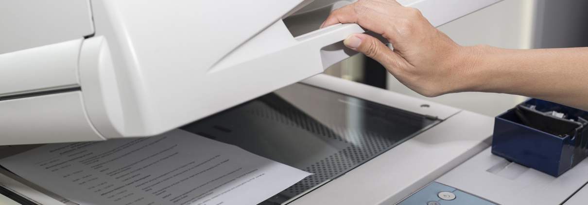 close up of a woman making a copy of a document on a copier machine