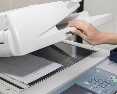 close up of a woman making a copy of a document on a copier machine