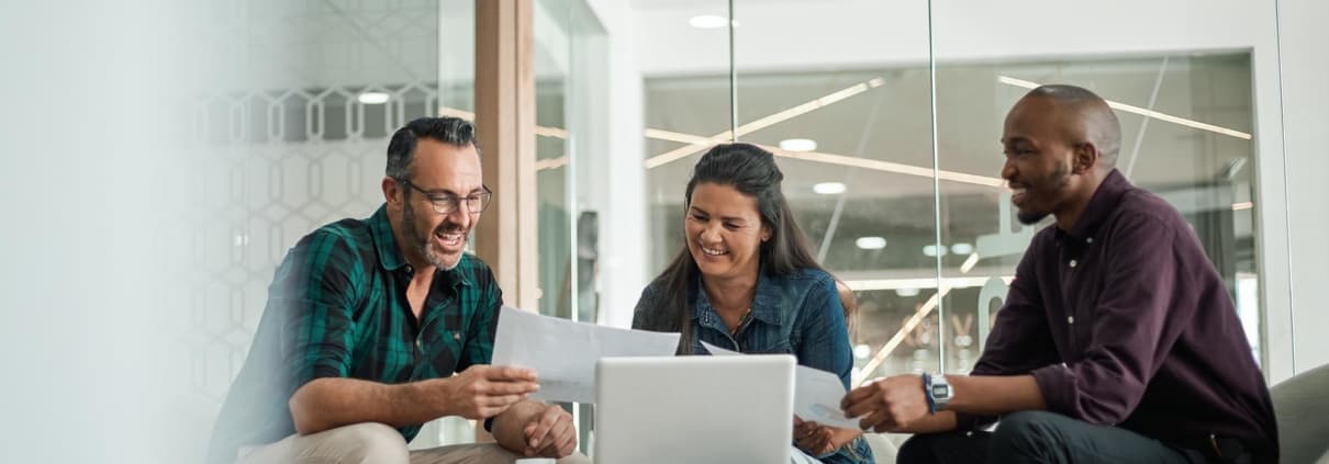 three coworkers working on a laptop