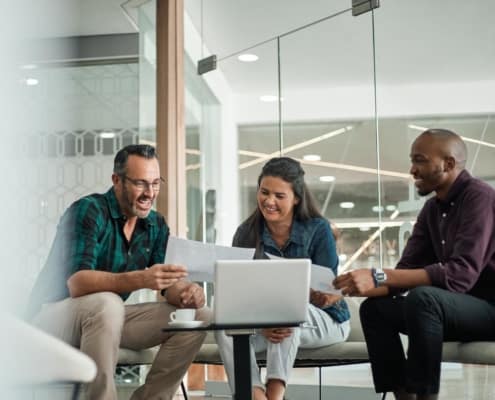 three coworkers working on a laptop