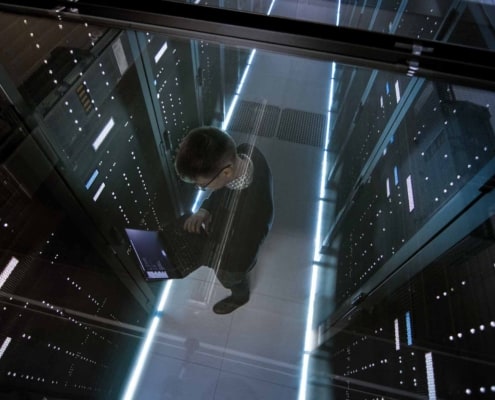 man working on a laptop in a data center