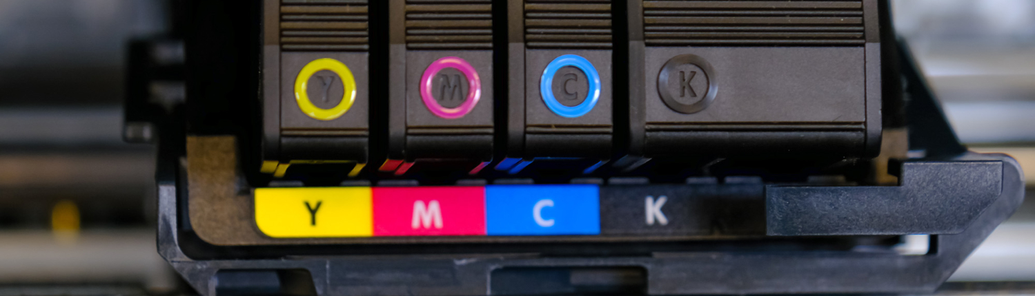 Close up of yellow, magenta, cyan, and black ink printer cartridges