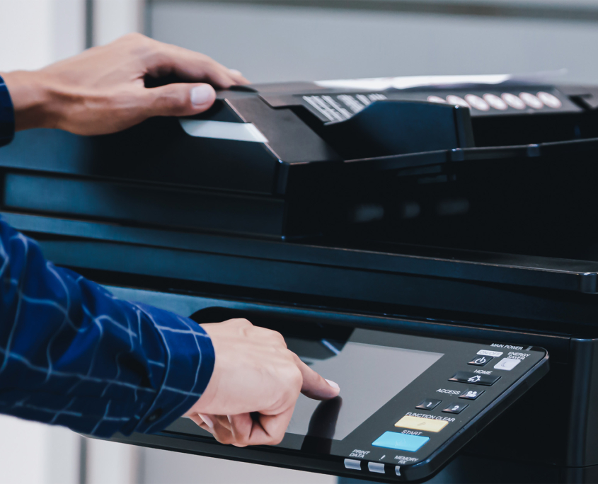 Side view of a man in flannel shirt operating large printer