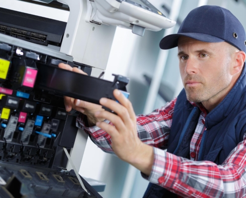 Worker changing ink on copier machine