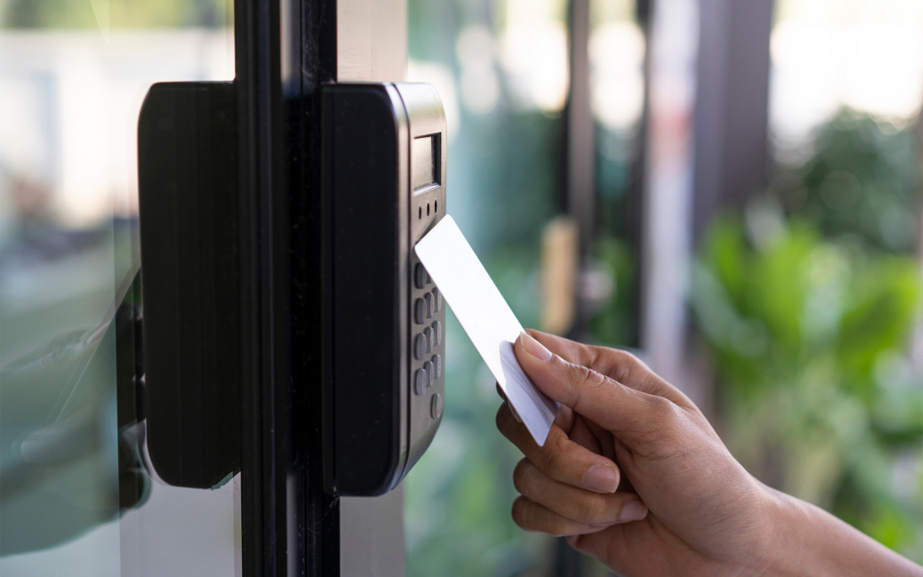 Hand Holding Access Card Up To Commercial Door