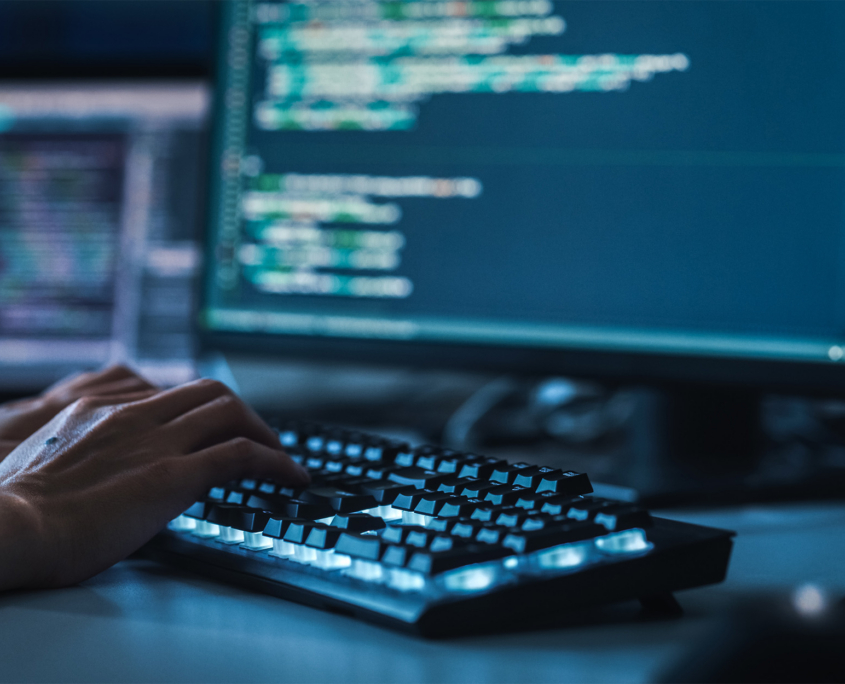 Hands Typing On A Keyboard With View Of Code