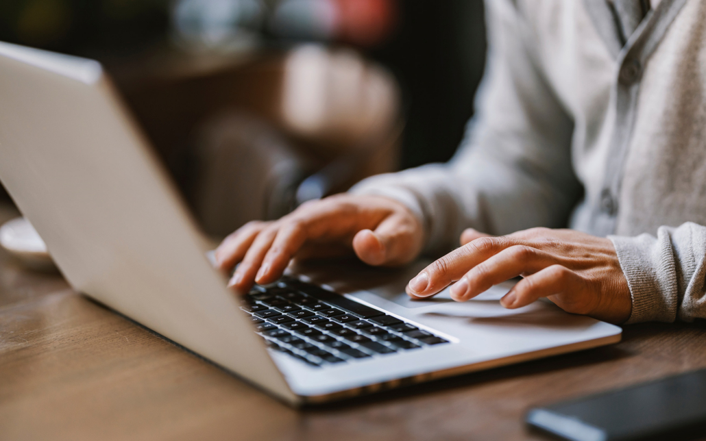 View Of Hands Typing On Laptop